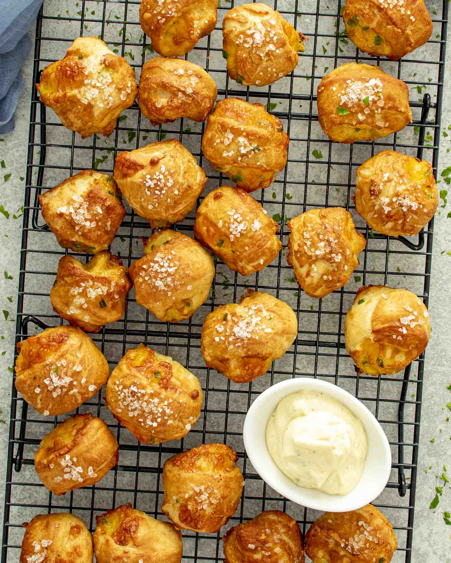 Freshly baked cheesy jalape&ntilde;o pretzel bites cooling on a wire rack, golden brown with coarse salt sprinkled on top.