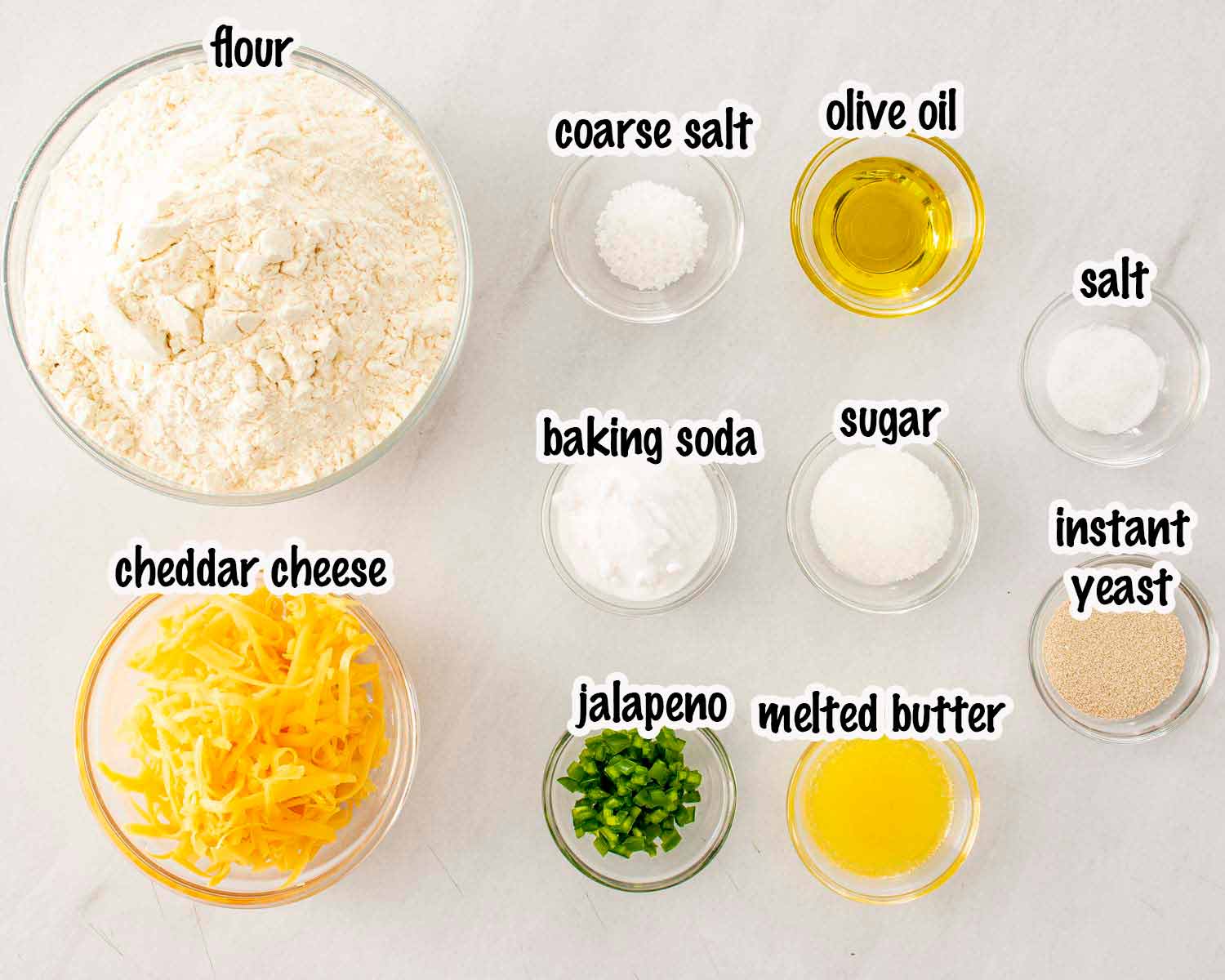 Ingredients for cheesy jalape&ntilde;o pretzel bites including flour, cheddar cheese, jalape&ntilde;o, yeast, baking soda, butter, and salt.