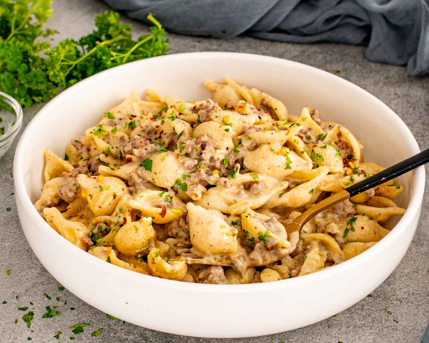 Creamy Beef and Shells served in white bowl with ground beef and silky cheddar cream sauce.
