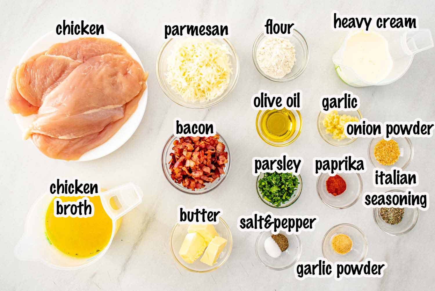 Ingredients for creamy garlic parmesan chicken including chicken breasts, Parmesan cheese, garlic, cream, butter, broth, and seasonings.