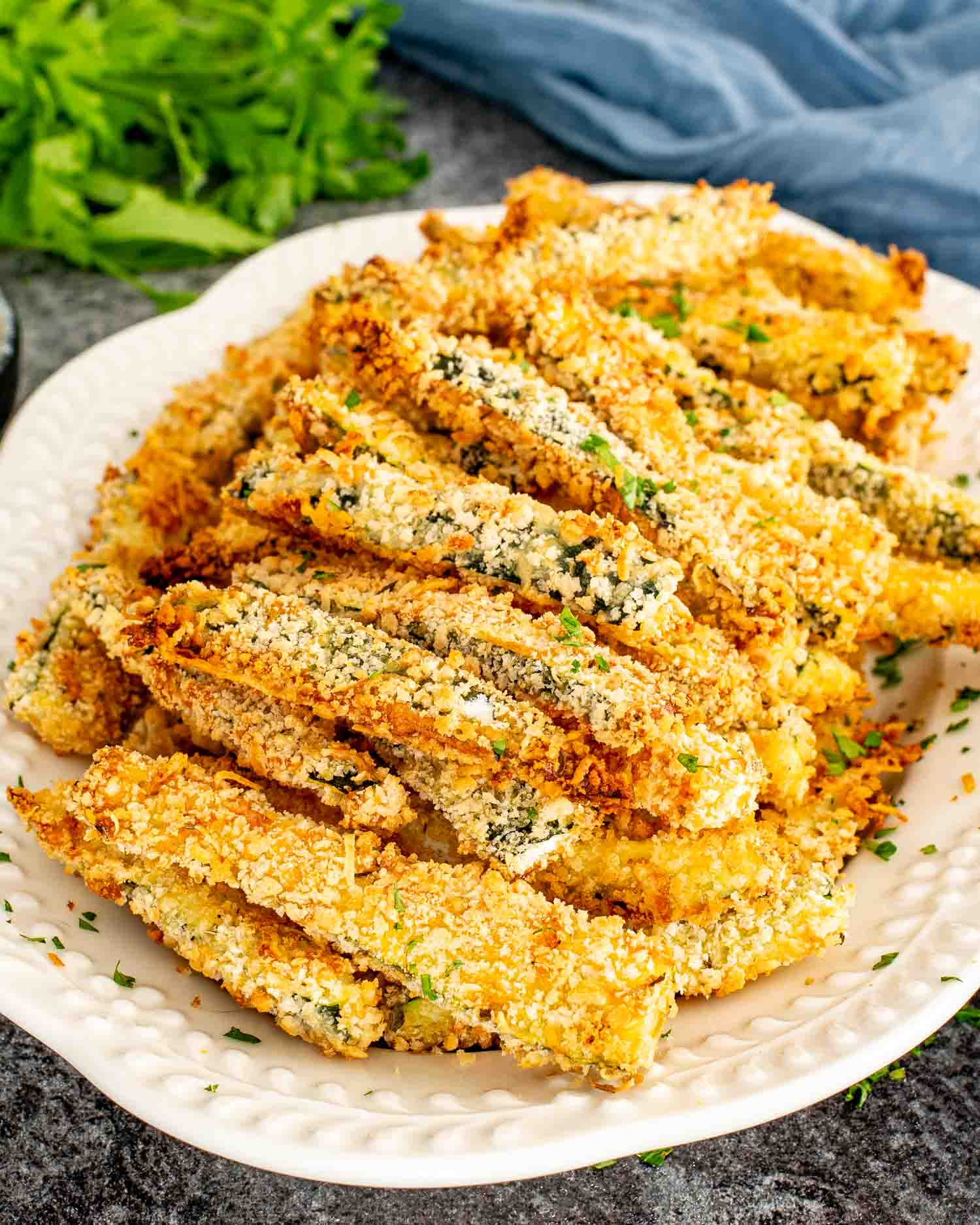 Close up of crispy baked zucchini fries showing golden coating and tender zucchini center.