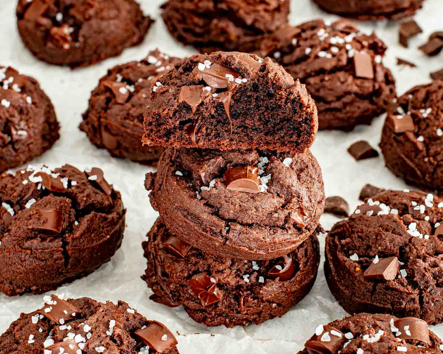 Close up of double chocolate fudge cookie broken in half showing soft fudgy center and melted chocolate chunks.