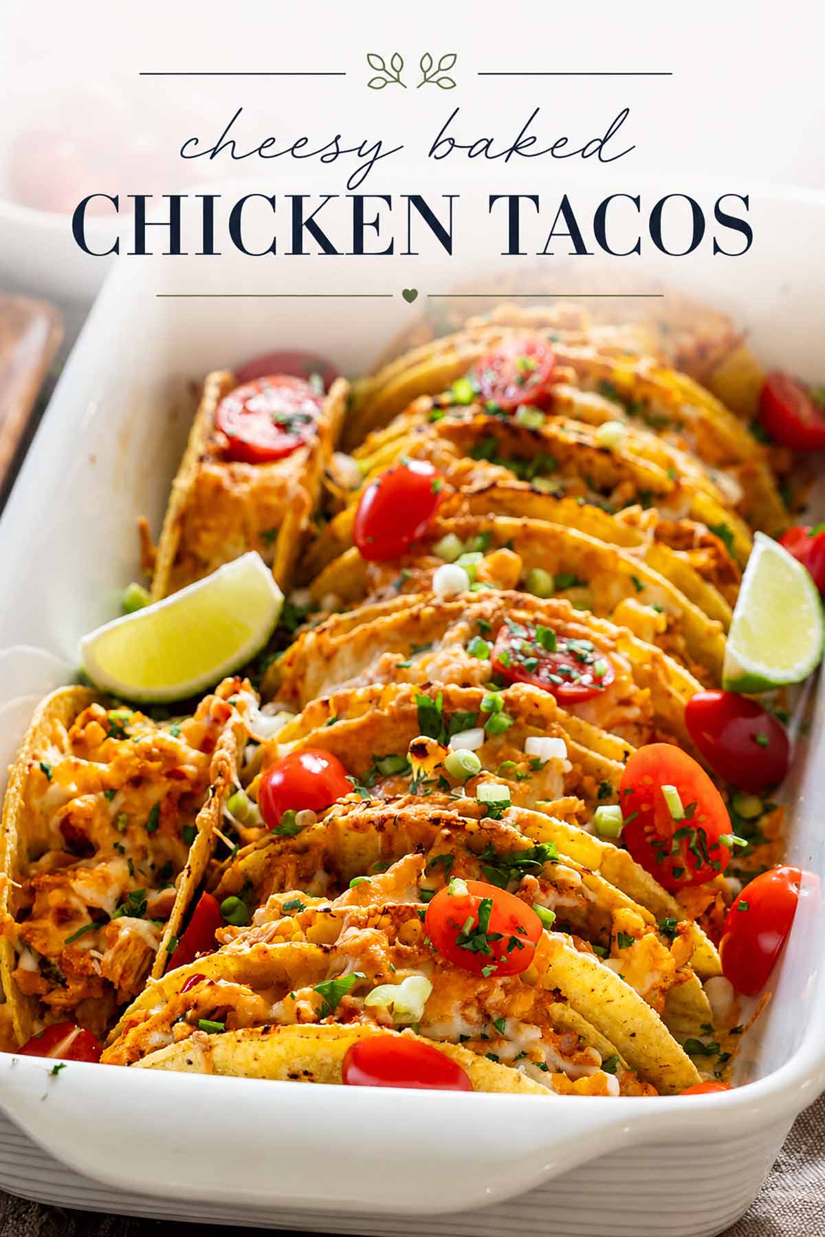 Cheesy baked chicken tacos arranged in a casserole dish, topped with tomatoes and green onions beneath elegant title text.