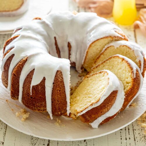 Whole pineapple cream cheese pound cake covered in silky pineapple glaze, revealing a rich, buttery interior crumb.