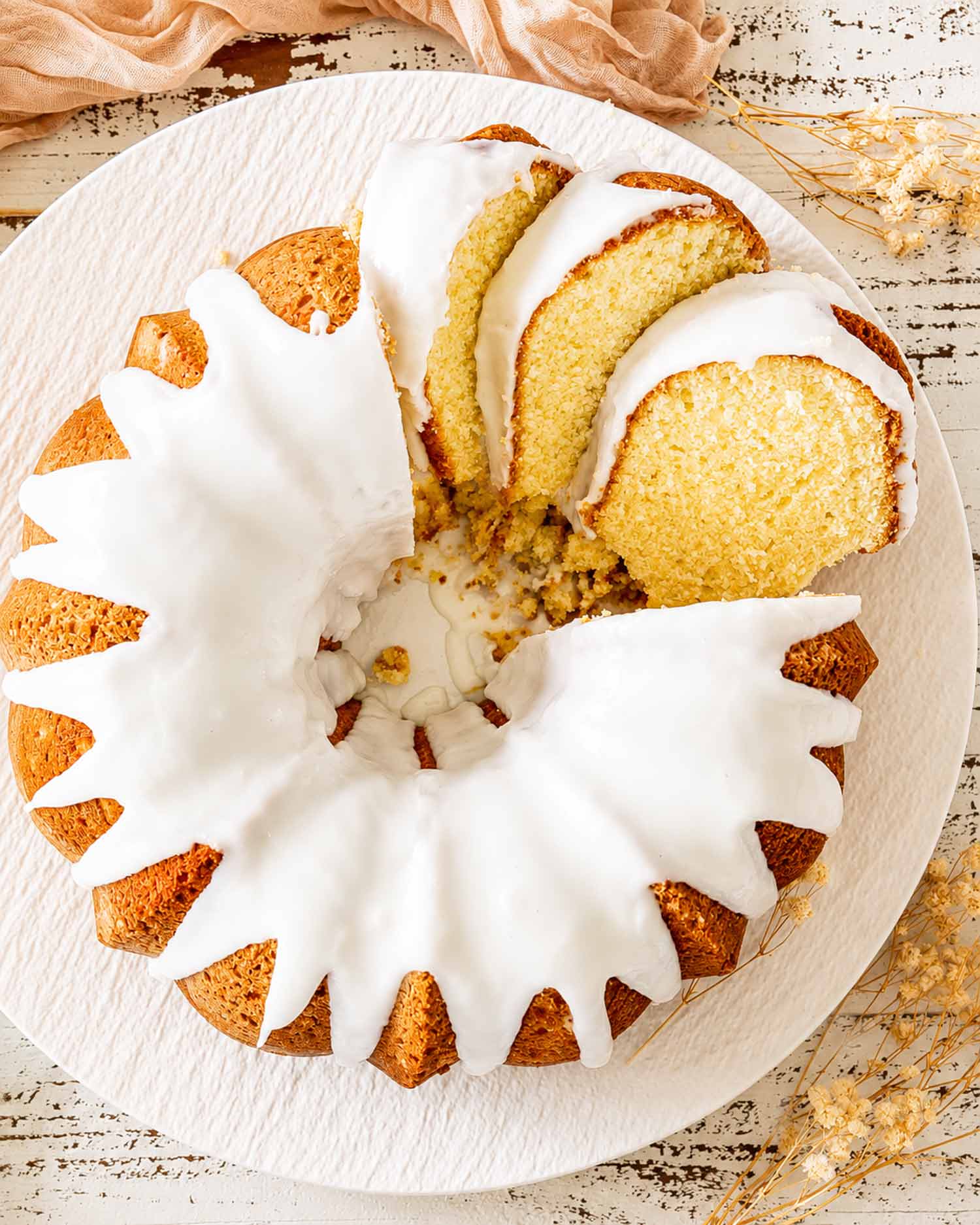 Overhead view of pineapple cream cheese pound cake topped with thick pineapple glaze, with several slices removed.