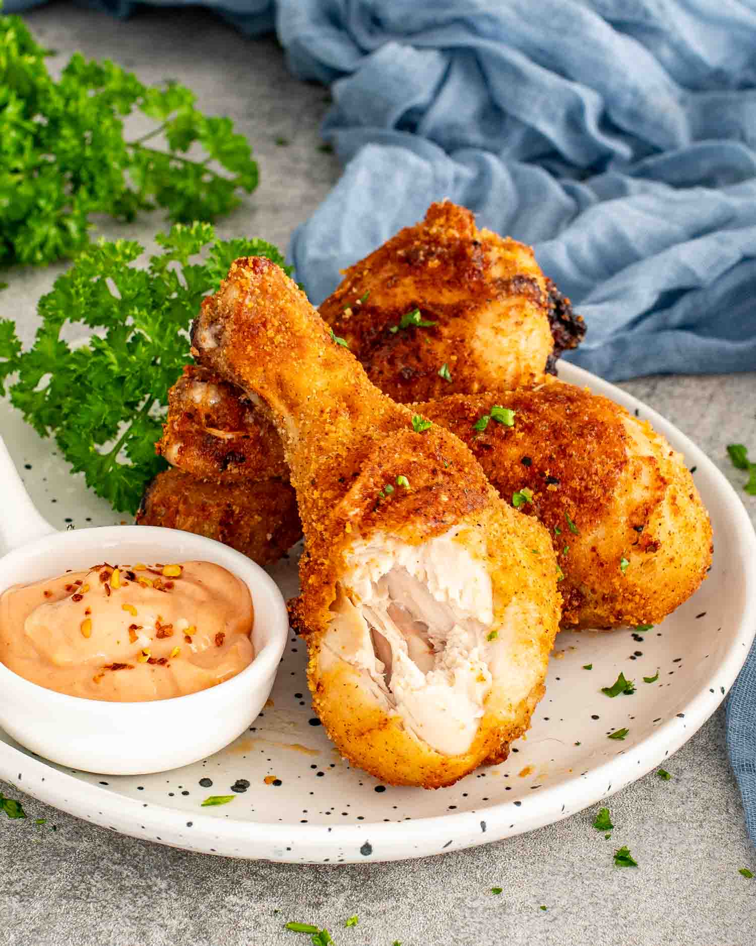 Crispy Air Fryer Shake-and-Bake Chicken served with a creamy dipping sauce, revealing juicy, tender meat beneath the crunchy coating.