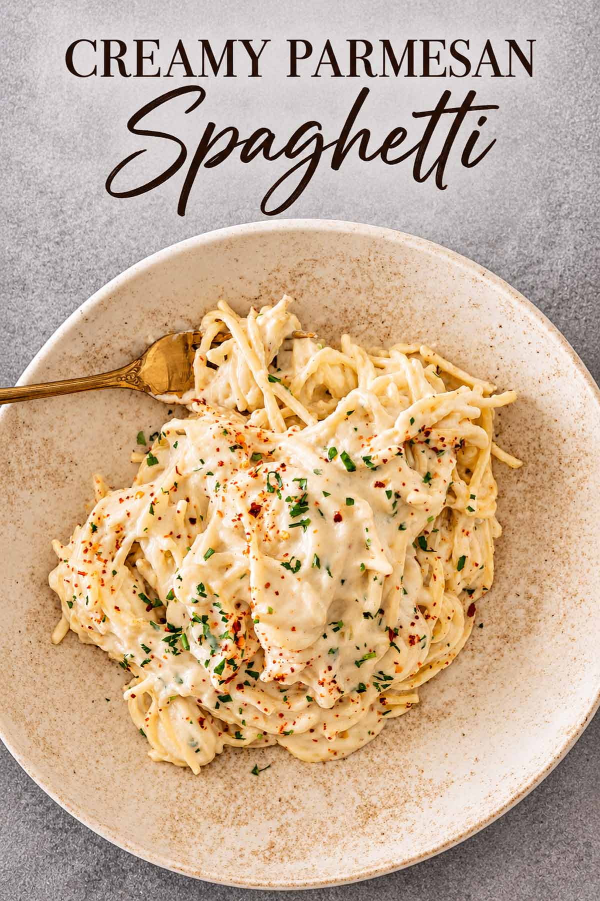 Creamy Parmesan spaghetti served in a shallow bowl with red pepper flakes, parsley, and an elegant recipe title above.