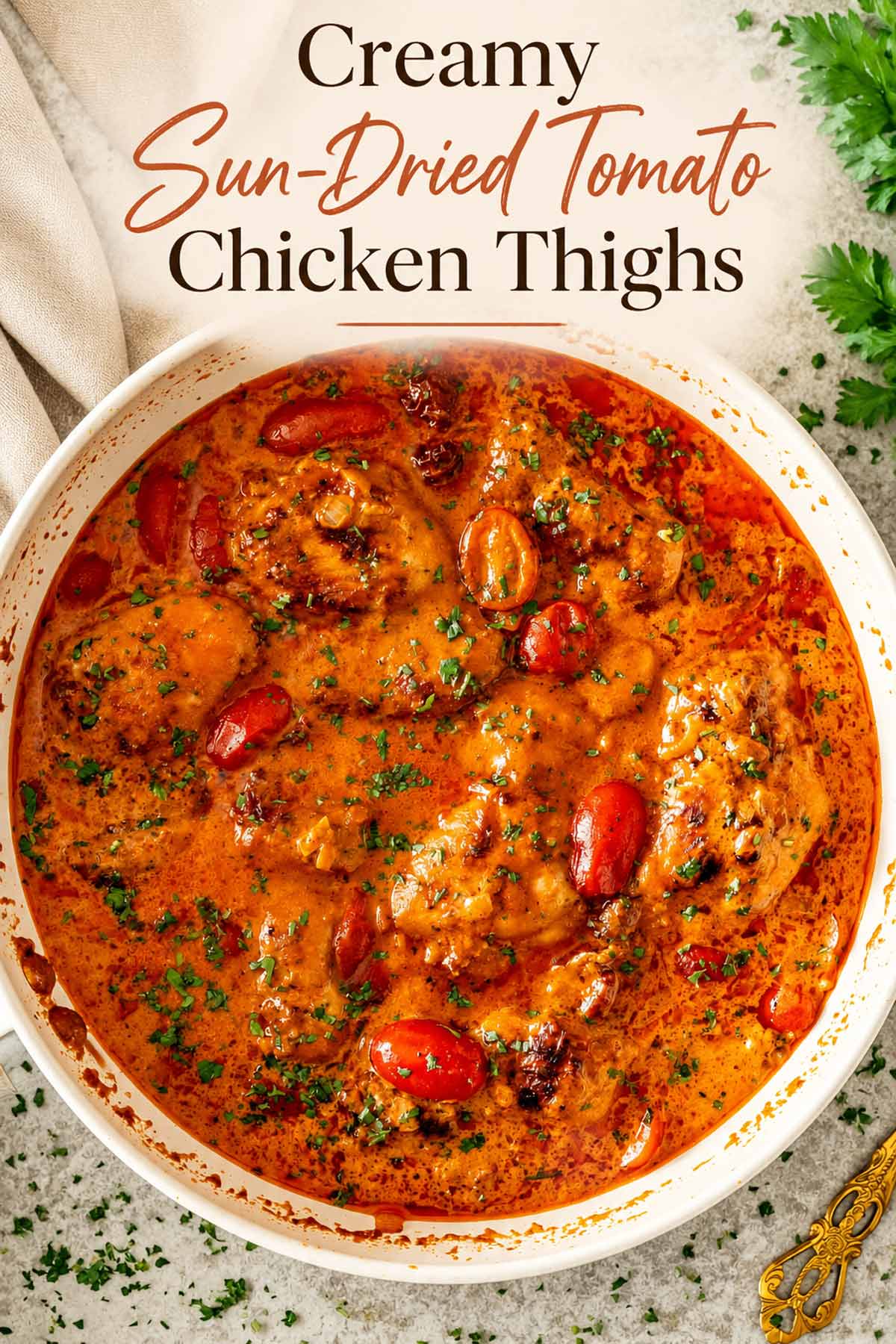 Overhead skillet of creamy sun-dried tomato chicken thighs with an elegant recipe title in warm AMC colors.