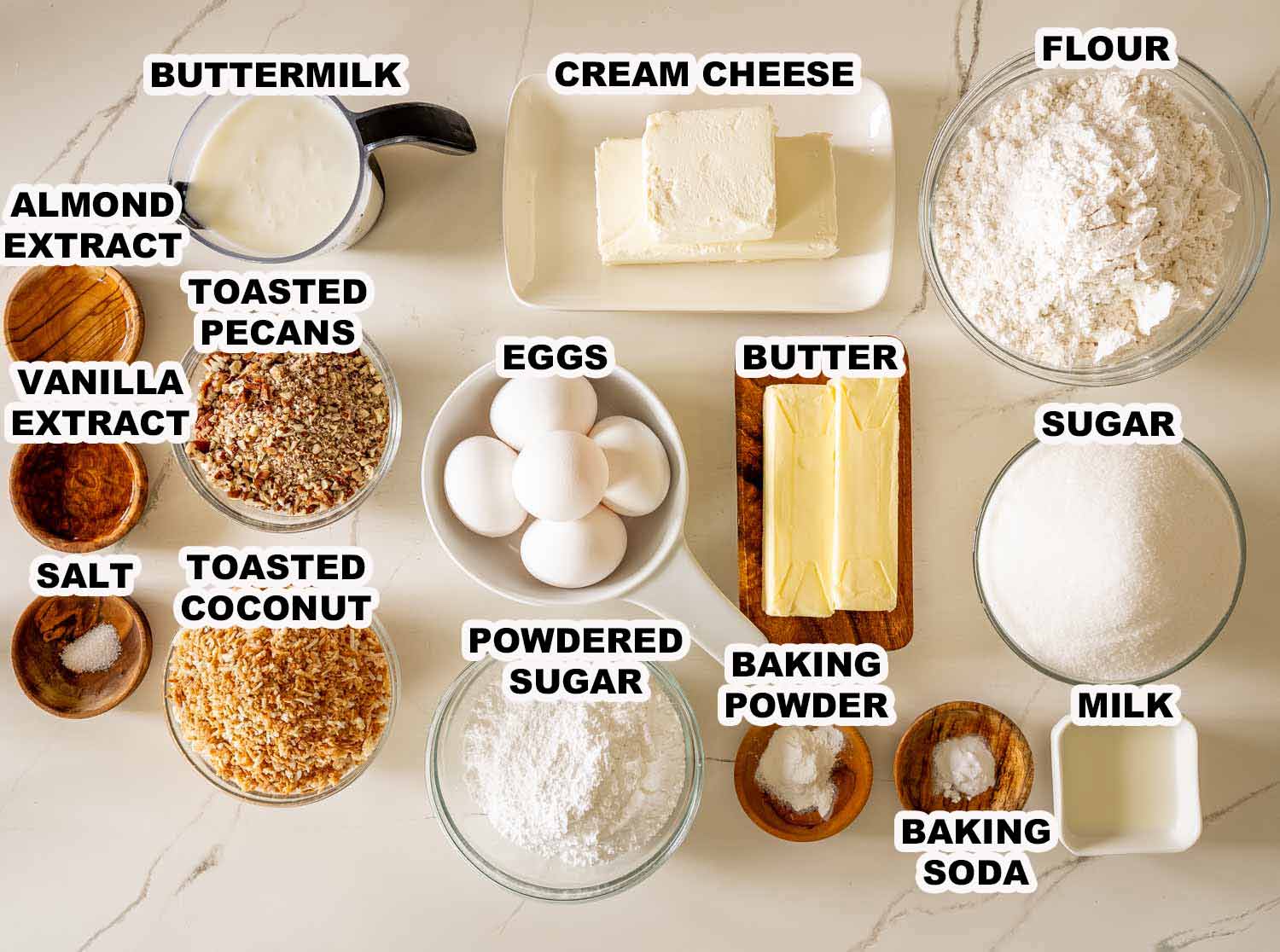Labeled ingredients for toasted coconut Italian cream Bundt cake, including flour, eggs, butter, cream cheese, coconut, and pecans.