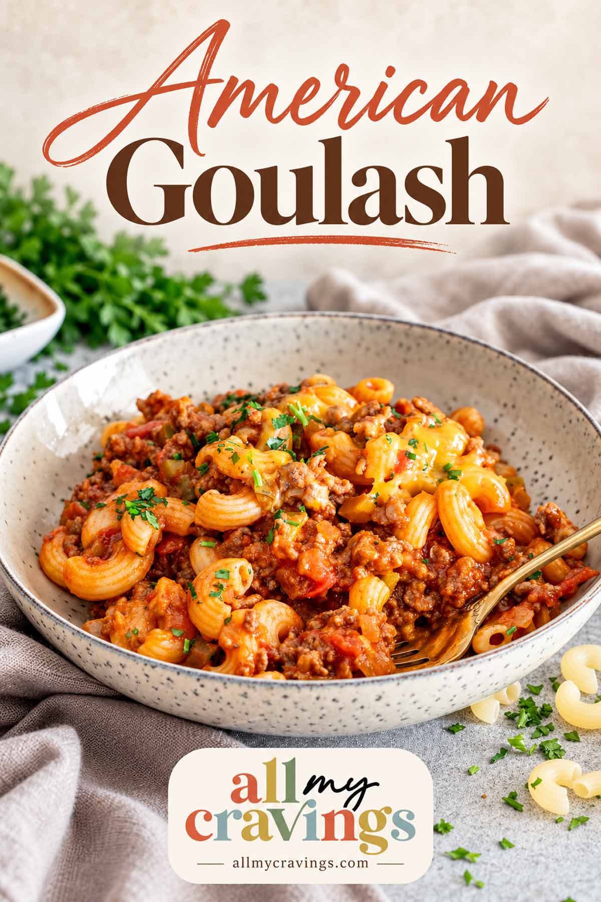 American Goulash title above a bowl of cheesy beef macaroni, with a gold fork and All My Cravings logo.