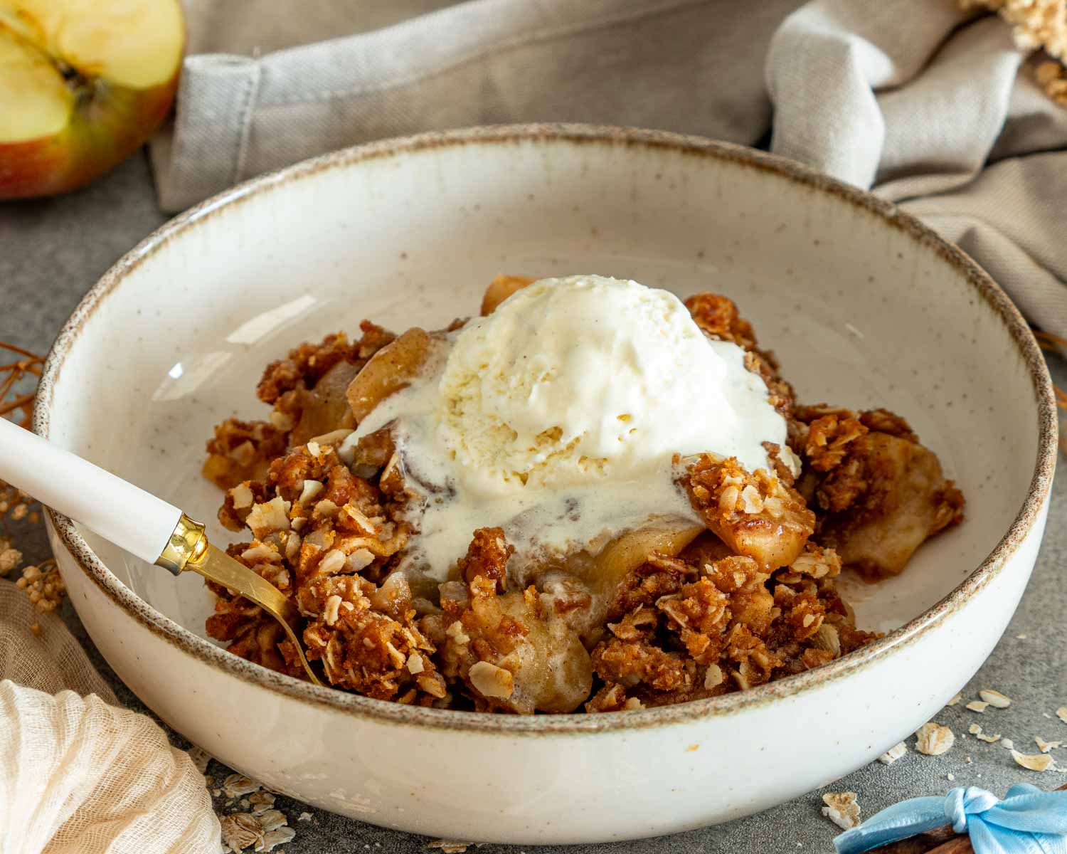 Warm apple crisp with tender cinnamon apples, crunchy oat topping, and a melting scoop of vanilla ice cream.