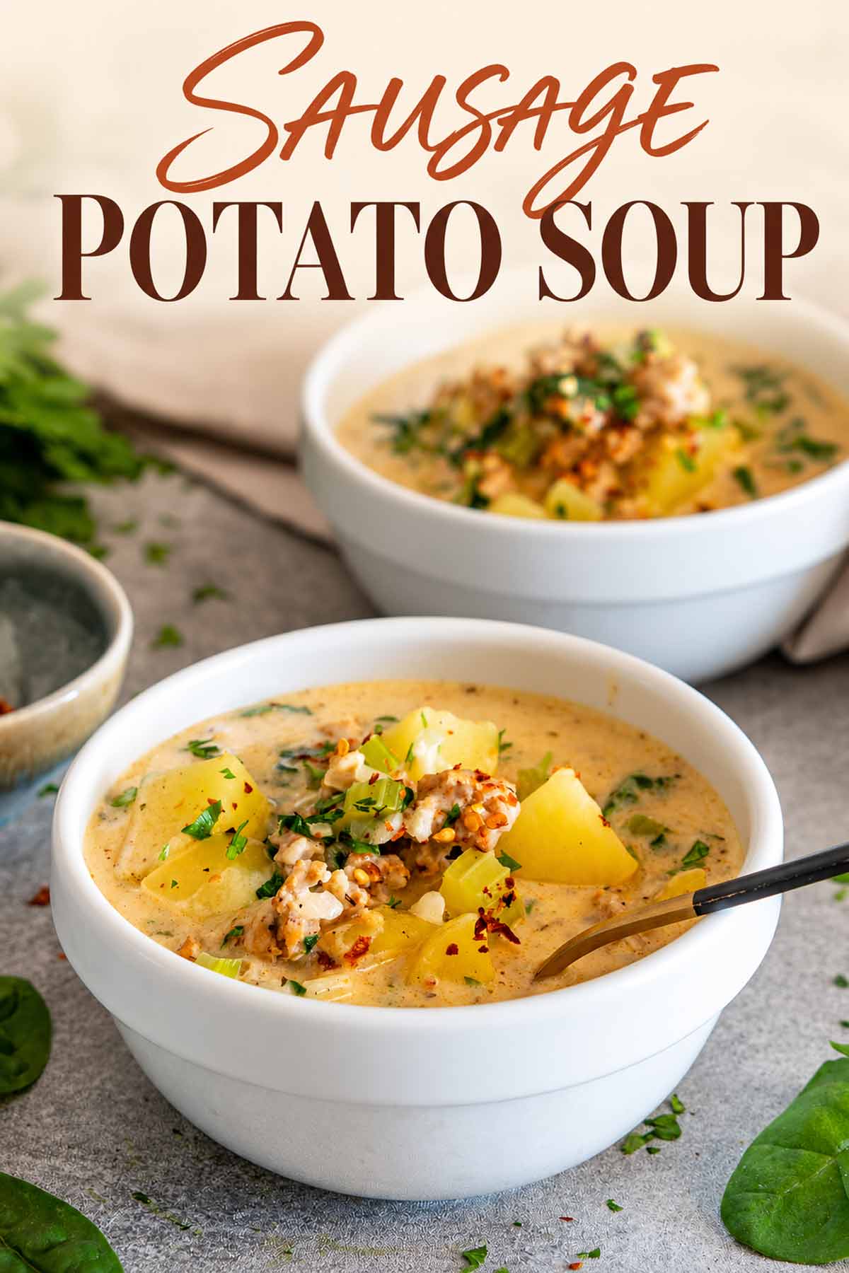 Pinterest graphic featuring two bowls of creamy sausage potato soup with spinach, herbs, tender potatoes, and an elegant title overlay.